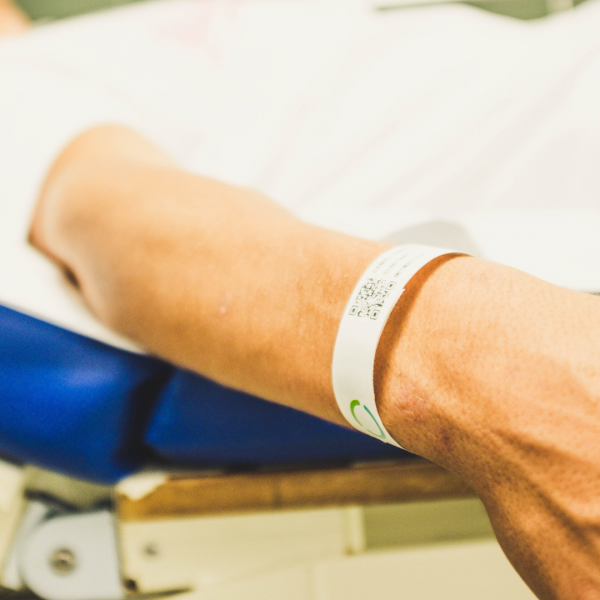 patient dans un lit d'hôpital avec son bracelet d'identification